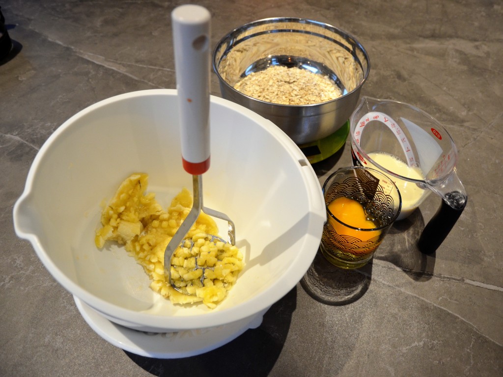 Prak de banaan met een aardappelstamper. Weeg 150 g havervlokken af. Meet 200 mL sojamelk af. Breek de eieren in een glas.